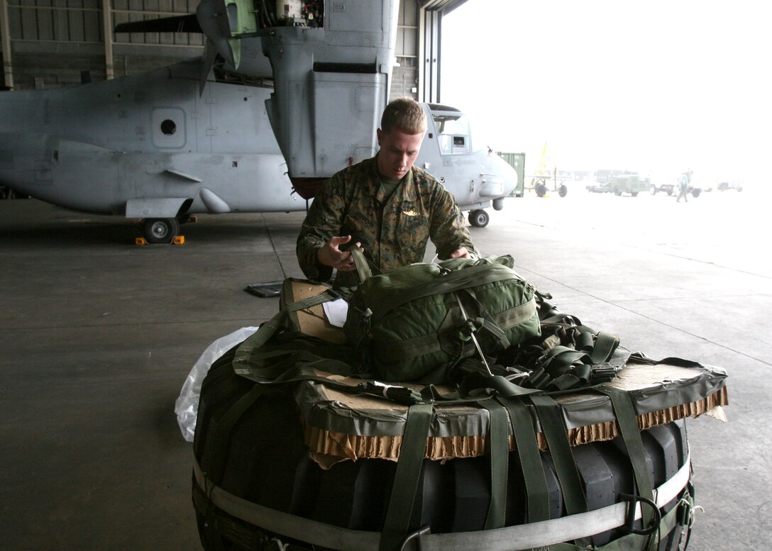 Cpl. Kenneth P. Vanhorn, 2nd Marine Logistics Group parachute rigger, makes sure the parachute is secured to the cargo. Marines of Marine Medium Tiltrotor Squadron 365 trained to perform aerial deliveries, Nov. 22.