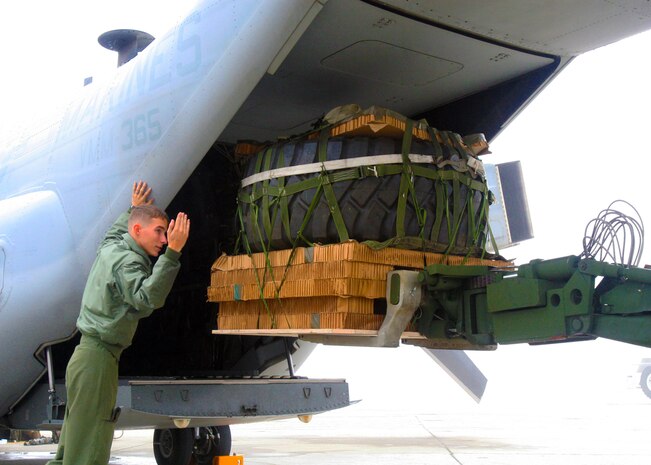 Cpl. Brandon S. Griffith, VMM-365 Osprey crew chief, directs cargo loaded onto the aircraft. Marines of Marine Medium Tiltrotor Squadron 365 trained to perform aerial deliveries, Nov. 22.