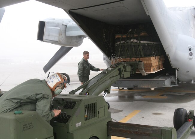 Staff Sgt. Lester I. Chase, VMM-365 Osprey mechanic, loads the cargo while Cpl. Brandon S. Griffith, VMM-365 Osprey crew chief, directs it. Marines of Marine Medium Tiltrotor Squadron 365, aboard Marine Corps Air Station New River, N.C., trained to perform aerial deliveries, Nov. 22.