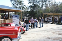 Volunteers from Professional Supporting Charities greet incoming participants to the barbecue while the band Stopping Time plays music for the supporters there. Harbor Site Bar hosted a charity barbecue to help raise money for a house to be built for a wounded Sneads Ferry Marine, Dec. 4.