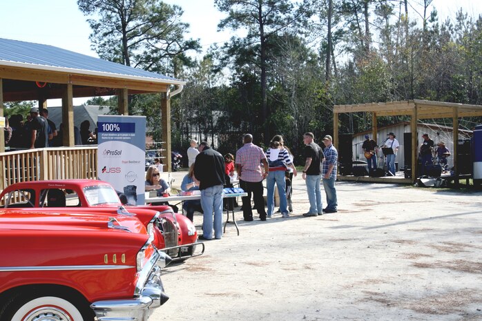 Volunteers from Professional Supporting Charities greet incoming participants to the barbecue while the band Stopping Time plays music for the supporters there. Harbor Site Bar hosted a charity barbecue to help raise money for a house to be built for a wounded Sneads Ferry Marine, Dec. 4.