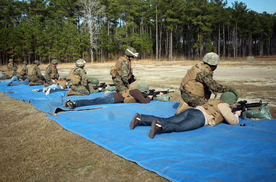 Spouses shoot M-16 A4 service rifles during Jane Wayne Day with Combat Logistics Regiment 27, 2nd Marine Logistics Group aboard Camp Lejeune, N.C., Dec. 9, 2011. Spouses dawned flacks and Kevlar helmets to lay rounds down range at a target approximately 50 meters away. (U.S. Marine Corps photo by. Pfc. Franklin E. Mercado)