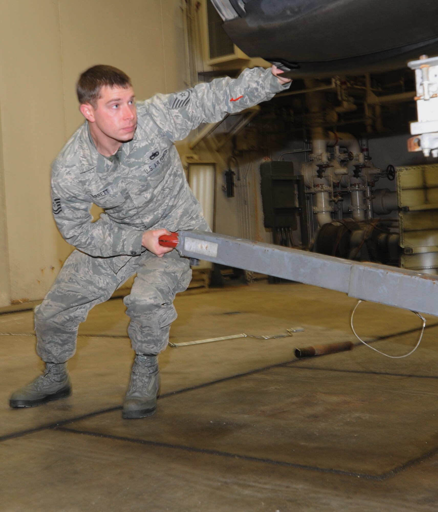 U.S. Air Force Tech. Sgt. Shawn Barrett, 14th Aircraft Maintenance Unit aerospace propulsion specialist NCO in charge, steers an engine under an F-16 Fighting Falcon aircraft at Misawa Air Base, Japan, Feb. 15, 2012. The responsibility of an engine specialist is to make sure the F-16 engine operates well, schedule maintenance and replace parts of an engine. (U.S. Air Force photo by Airman Kenna Jackson/Released)