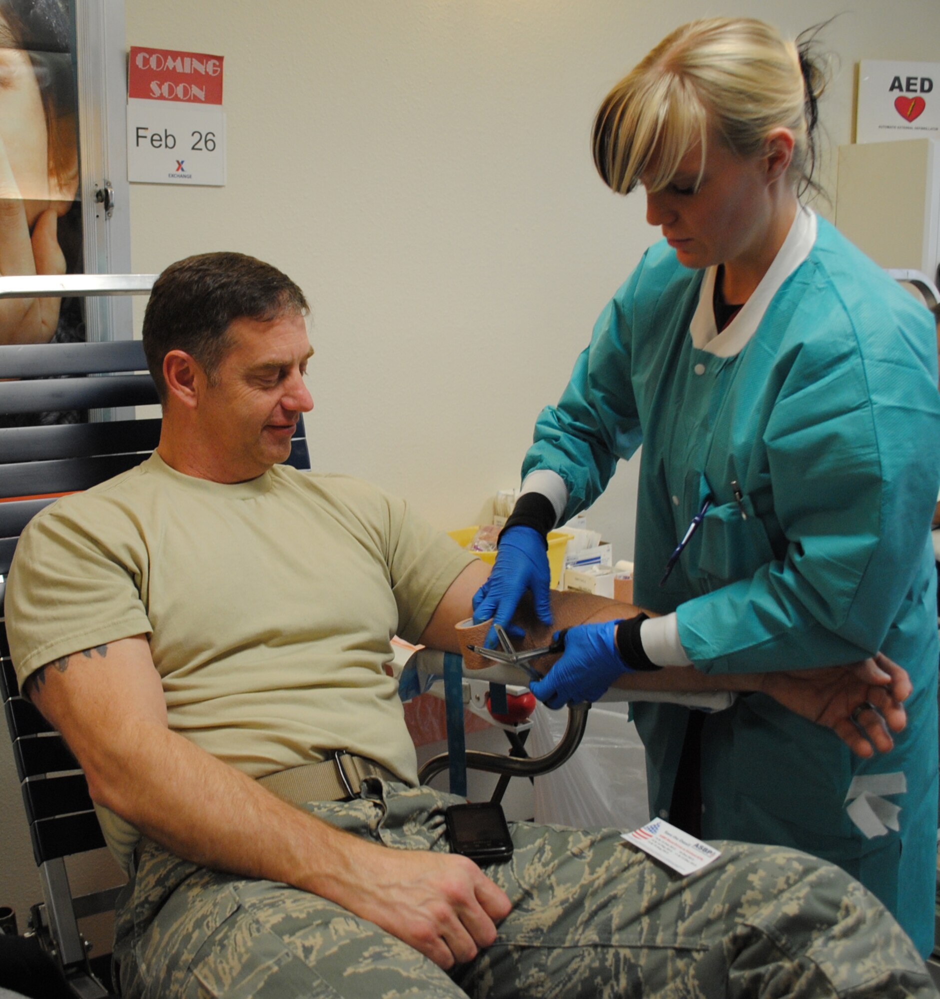 KIRTLAND AFB, N.M. – Elisa Lombardo, Armed Services Blood Program technician, wraps the arm of Master Sgt. David Randall, 150th Fighter Wing, during the ASBP blood drive Feb. 15 at the base theater. (Photo by Jonathan Rejent)