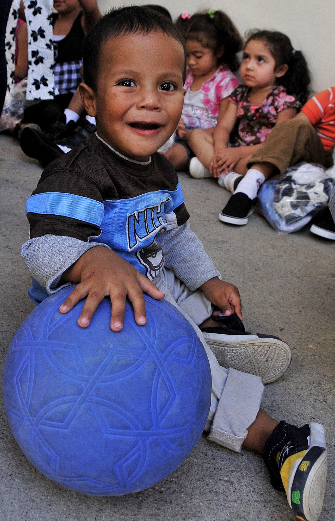 A toddler at the Instituto El Cordero maintains control of one of the soccer balls given to the school by the Honduran Air Force Feb. 14.  More than 20 air advisors from the Air Mobility Command's 571st Mobility Support Advisory Squadron and Airmen from the Honduran Air Force extended their building partner capacity mission to the community by visiting two Honduran schools Feb. 14 and 17.  (U.S. Air Force photo by Tech. Sgt. Lesley Waters)