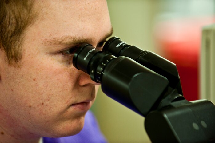 Airman 1st Class Brian Childers, medical lab technician, 99th Medical Support Squadron, analyzes blood cells through a microscope Feb. 17th, 2012, inside the Mike O'Callaghan Federal Medical Center, Nellis Air Force Base, Nev. The 99th MDSS medical laboratory is responsible for a wide variety of tasks utilizing six working sections to analyze, confirm and test different medical samples. Their analysis aids in the diagnosis and treatment of patients. (U.S. Air Force photo by Senior Airman Brett Clashman)