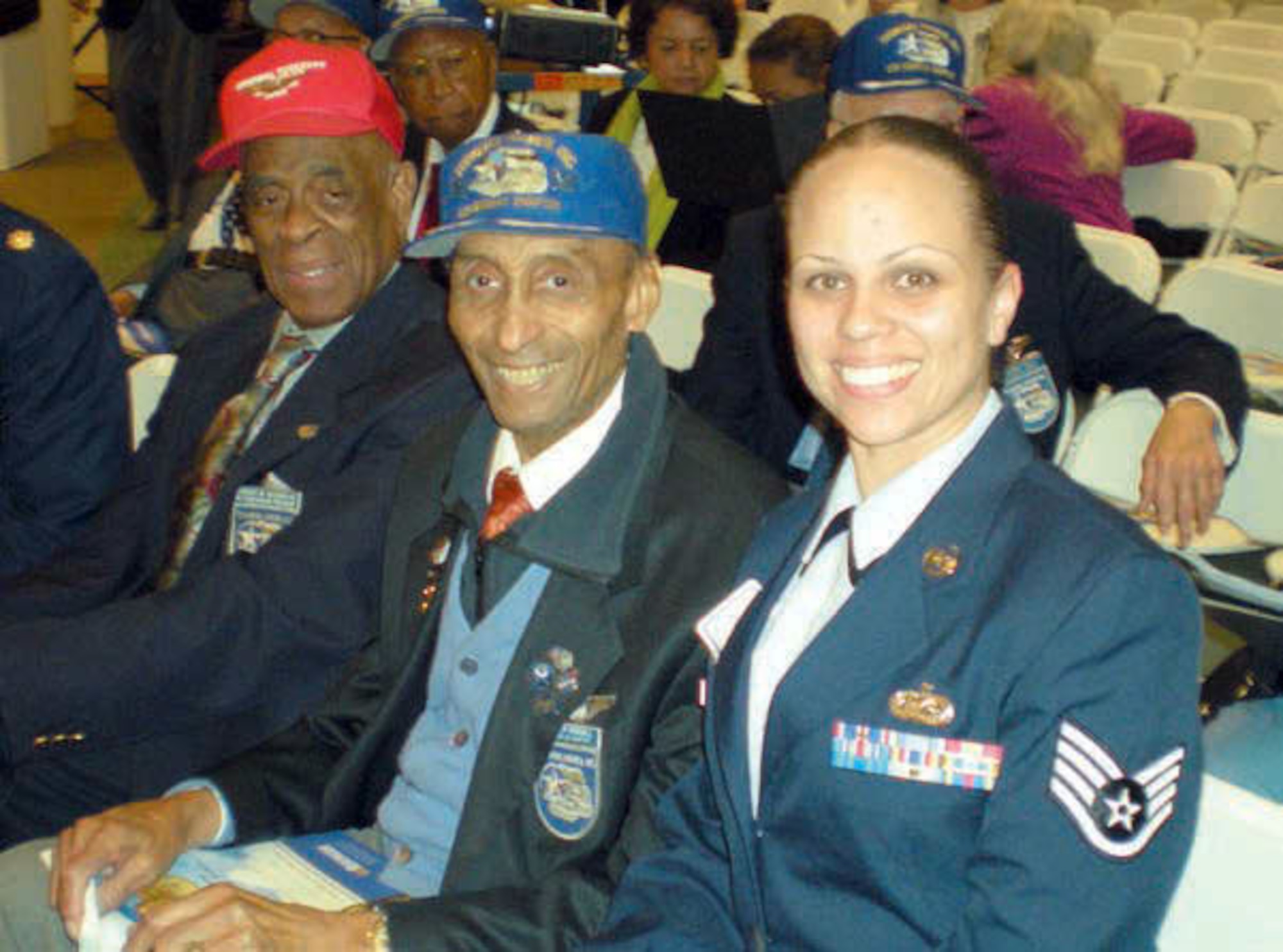 Staff Sgt. Aja Smith, 50th Aerial Port Squadron, March Air Reserve Base, Calif., sits beside Oliver Goodall (blue hat), Tuskegee Airmen, Los Angeles Chapter member and Edward W. Woodward, Tuskegee Airmen Western Region President at the Tuskegee Airmen International Convention. (U.S. Air Force photo/Staff Sgt. Aja Smith)