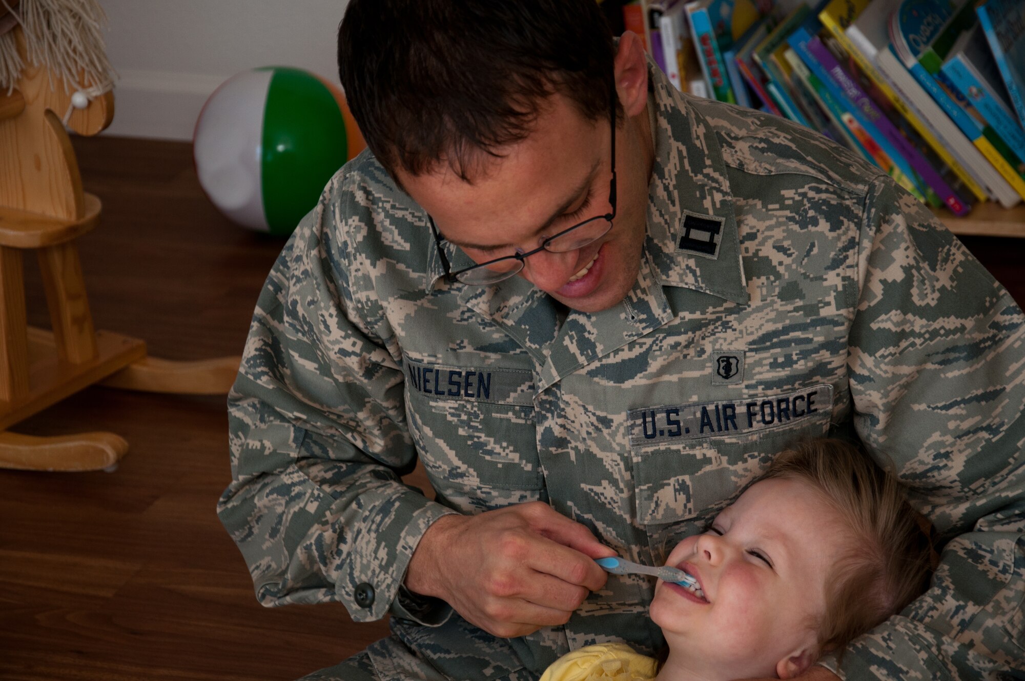 Capt. Matthew Nielsen, 21st Dental Squadron, brushes his daughter Carlee’s teeth, as part of a dental health month demonstration. During February, members of the 21st Dental Squadron visited the Peterson child development centers and local schools to promote Children’s Dental Health Month, educating about 1,150 children on how to care for their teeth. (U.S. Air Force photo)