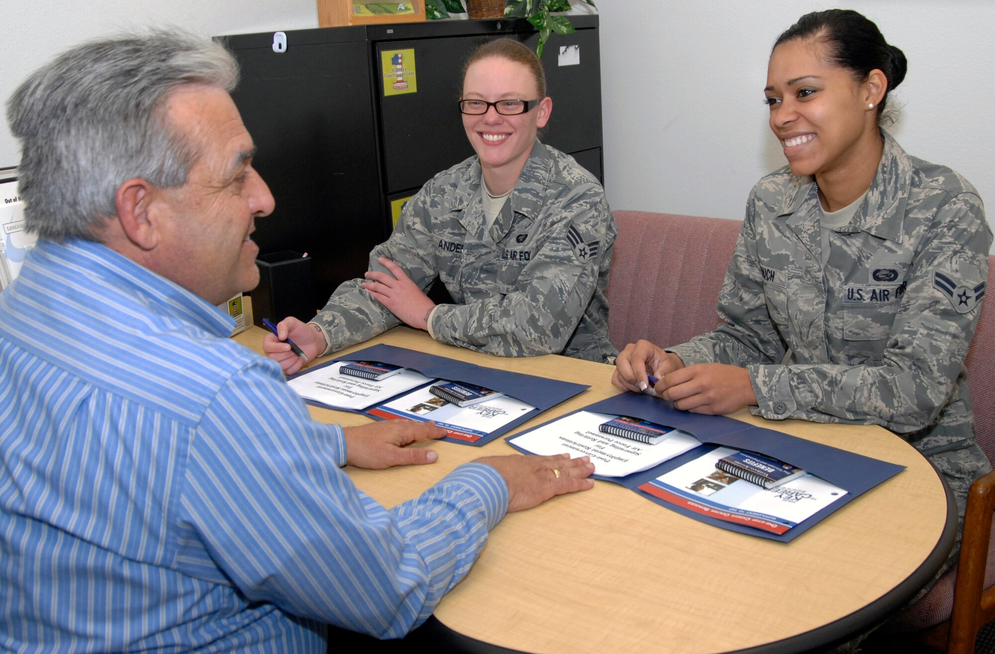 Glenn Arola, community readiness counselor at the 95th Air Base Wing's Airman and Family Readiness Center can sign participants up for the Preseparation Counseling Course and Department of Labor Employment Workshop, as well as provide career counseling sessions to servicemembers like Senior Airman Leslie Anderson (left), 95th Force Support Squadron, and Airman 1st Class Samantha Couch (right), 95 FSS. (U.S. Air  Force Photo by Laura Mowry)