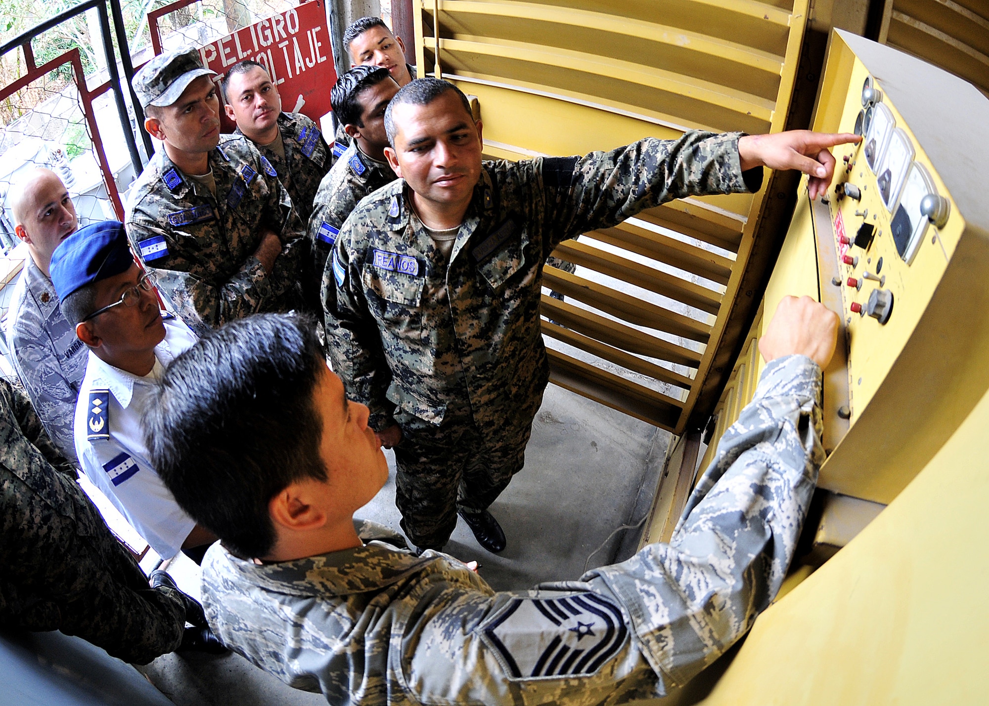 A Honduran Air Force Airman explains to Master Sgt. Ronald Hael, 571st Mobility Support Advisory Squadron power production air advisor, the function of the control gauges during the preoperational inspection on the generator at Col. Hernán Acosta Mejia Air Base, Tegucigalpa, Honduras, Feb. 13.  The Airmen, representing 15 Air Force specialties, are working side-by-side with Honduran Air Force members in developing the seven core competencies of air base defense, air traffic control, aircraft maintenance, aircrew survival, communications, generator maintenance and safety.  (U.S. Air Force photo by Tech. Sgt. Lesley Waters)