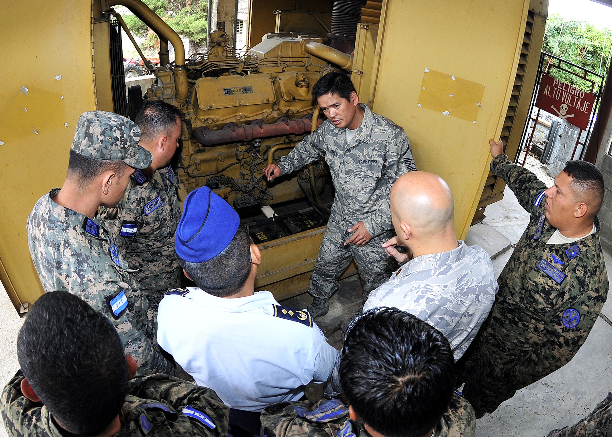 Master Sgt. Ronald Hael, 571st Mobility Support Advisory Squadron power production air advisor, explains to the Honduran Air Force the importance of preoperational inspection on the generator at Col. Hernán Acosta Mejia Air Base, Tegucigalpa, Honduras, Feb. 13.  A group of approximately 20 members of Air Mobility Command's 571st Mobility Support Advisory Squadron, alongside their Honduran Air Force counterparts, are participating in a month-long building partner capacity mission designed to enhance military-to-military relations between the two nations.  (U.S. Air Force photo by Tech. Sgt. Lesley Waters)