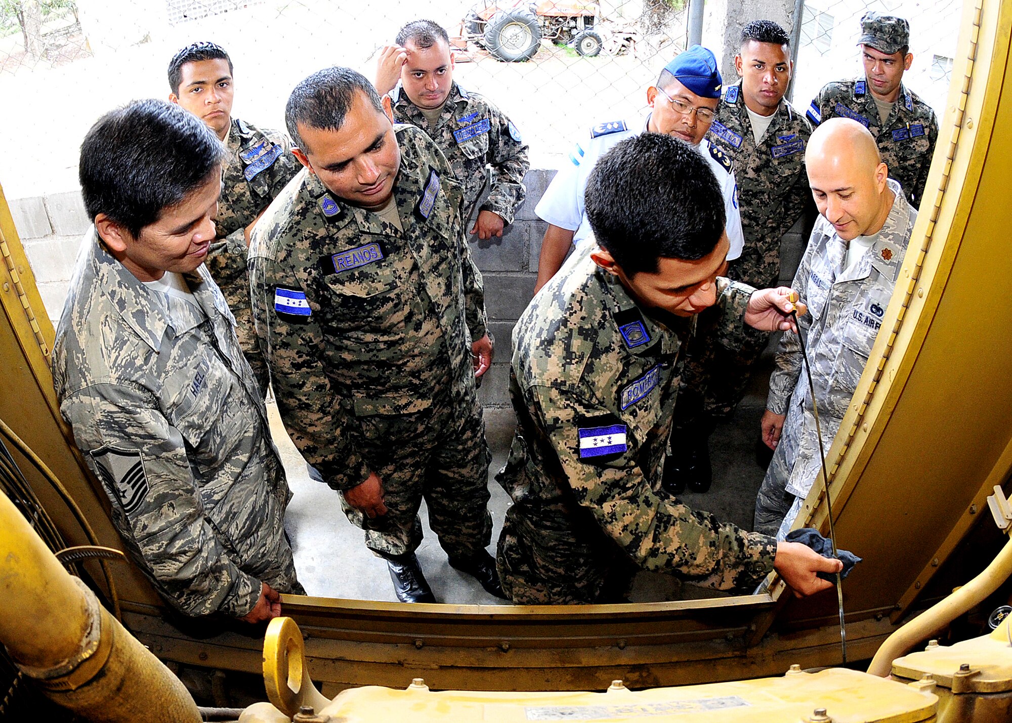 Master Sgt. Ronald Hael and Maj. Antonio Vargas, 571st Mobility Support Advisory Squadron air advisors, look on as a Honduran Air Force Airman show them how to check the oil during preoperational inspection of the generator at Col. Hernán Acosta Mejia Air Base, Tegucigalpa, Honduras, Feb. 13.  The 571 MSAS mission supports 12th Air Force's (Air Forces Southern) continued engagements in the U.S. Southern Command area of responsibility of Latin America and the Caribbean.  (U.S. Air Force photo by Tech. Sgt. Lesley Waters)