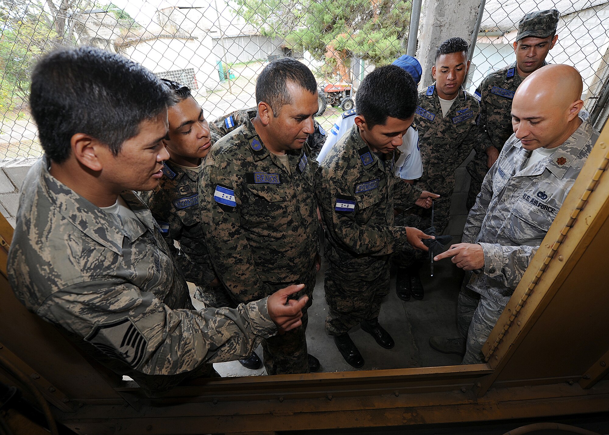 Master Sgt. Ronald Hael, 571st Mobility Support Advisory Squadron power production air advisor, looks on as Maj. Antonio Vargas, 571 MSAS air advisor, translates how to check the oil during preoperational inspection of the generator, at Col. Hernán Acosta Mejia Air Base, Tegucigalpa, Honduras, Feb. 13.  The building partner capacity mission, carried out by the 571 MSAS, is designed to promote regional stability by fostering key relationships and enhancing partner nation capabilities.  (U.S. Air Force photo by Tech. Sgt. Lesley Waters)