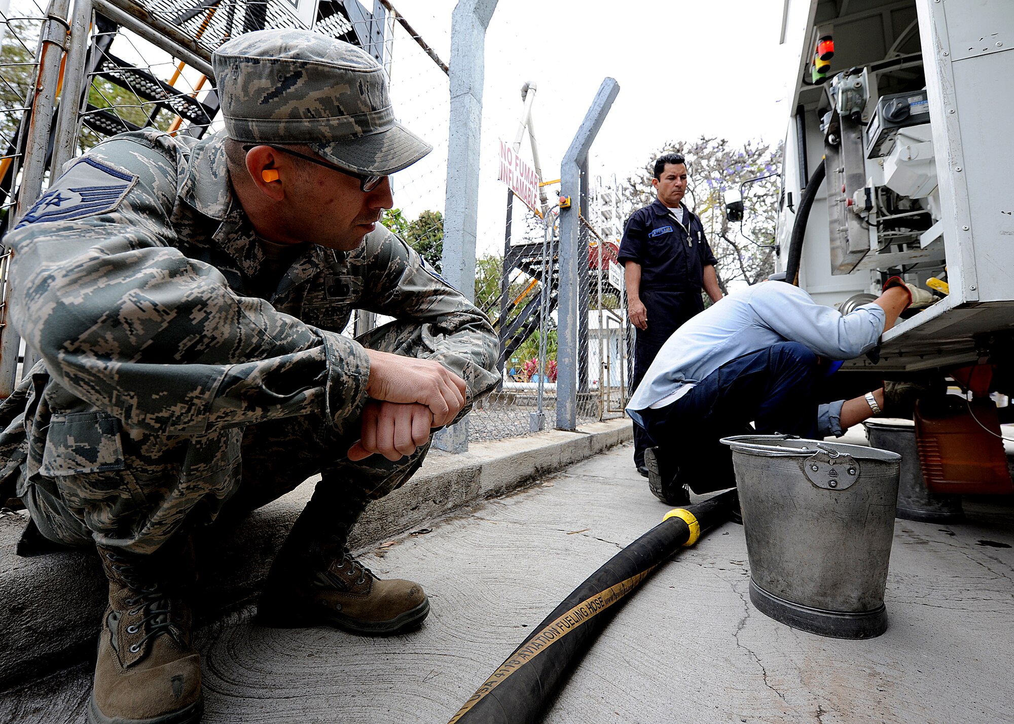 Master Sgt. Michael Raffa, 571st Mobility Support Advisory Squadron fuels air advisor, looks on as a Honduran contractor prepares the container for a fuel sample, in Tegucigalpa, Honduras, Feb. 13.  Approximately 20 members of Air Mobility Command's 571st Mobility Support Advisory Squadron, alongside their Honduran Air Force counterparts, are participating in a building partner capacity mission designed to enhance military-to-military relations between the two nations.  (U.S. Air Force photo by Tech. Sgt. Lesley Waters)