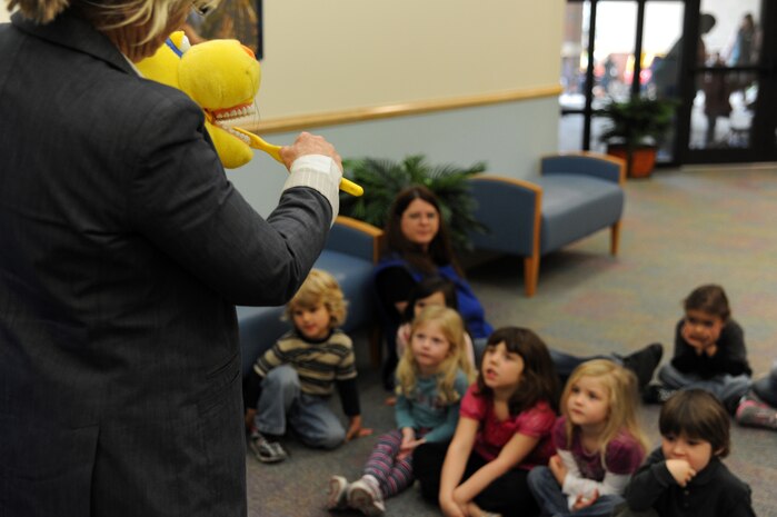 Children at the Child Development Center watch Gaye Adams demonstrate proper brushing techniques at Joint Base Charleston - Air Base Feb. 10. Every February, the American Dental Association sponsors National Children's Dental Health Month to raise awareness of the importance of children's oral health. Adams is the 628th Medical Group chief of preventive dentistry. (U.S. Air Force photo / Airman 1st Class Ashlee Galloway)