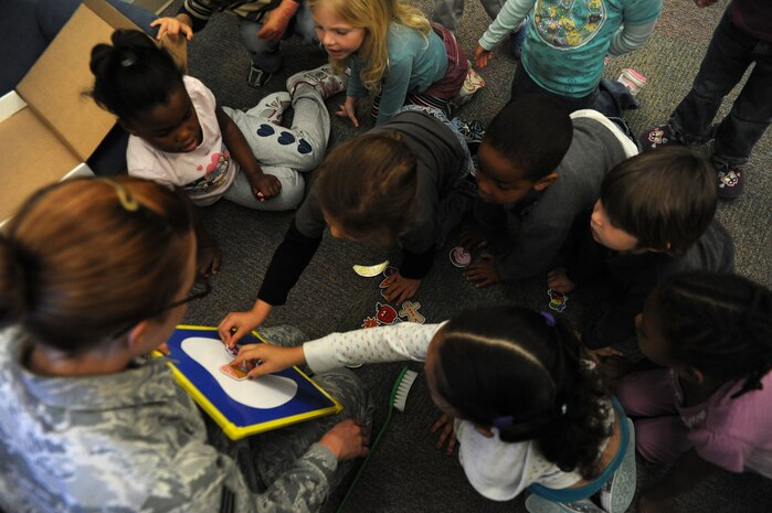 Children place magnets of healthy and non-healthy foods on a magnetic tooth, to show which foods are good and bad for your teeth. Every February, the American Dental Association sponsors National Children's Dental Health Month to raise awareness of the importance of children's oral health. (U.S. Air Force photo / Airman 1st Class Ashlee Galloway)