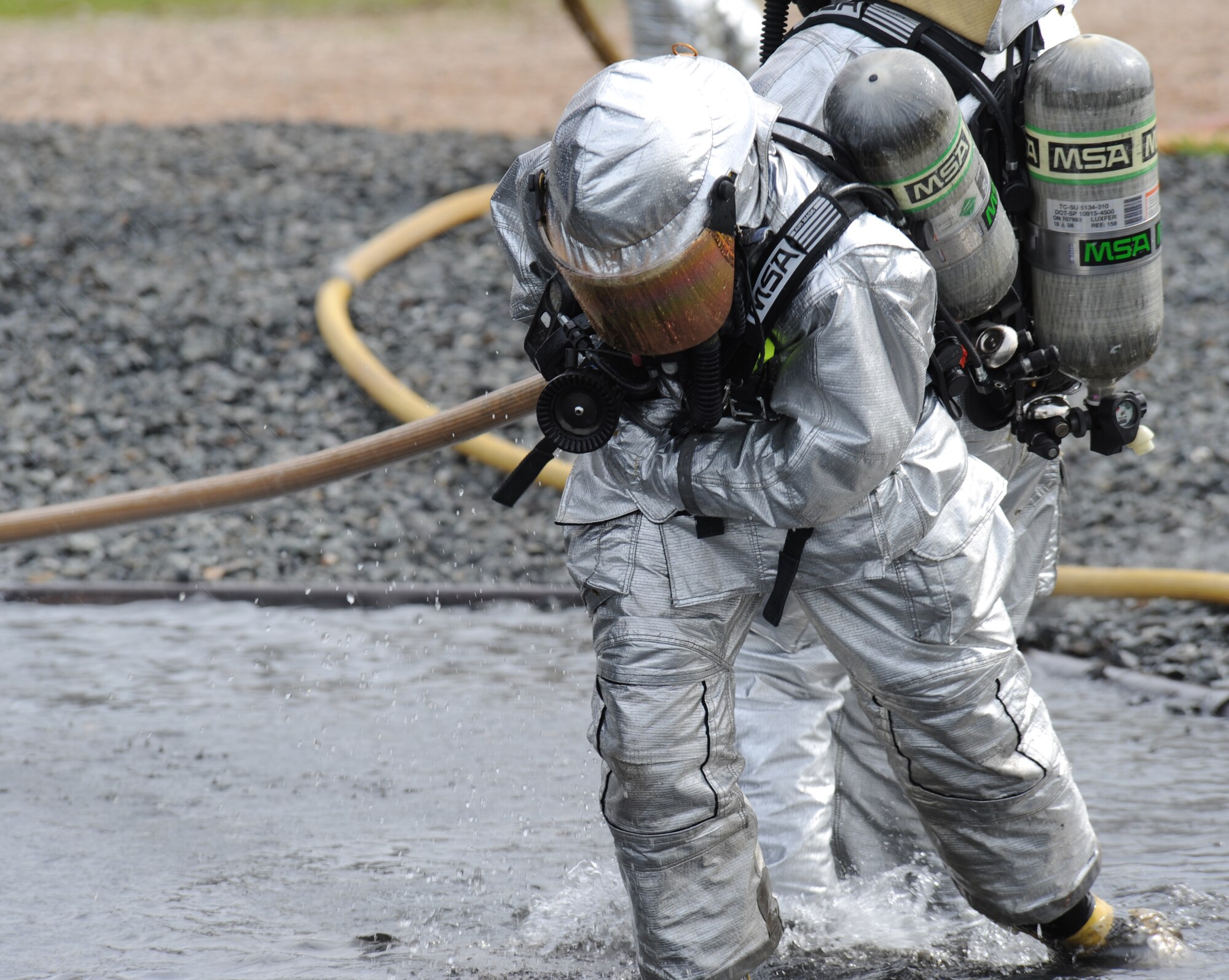 Firefighters from the 2nd Civil Engineer Squadron pull a fire hose during an exercise on Barksdale Air Force Base, La., Feb. 16. The exercise helps test and train emergency personnel on how to handle downed aircraft carrying nuclear weapons. (U.S. Air Force photo/Airman 1st Class Micaiah Anthony)(RELEASED)