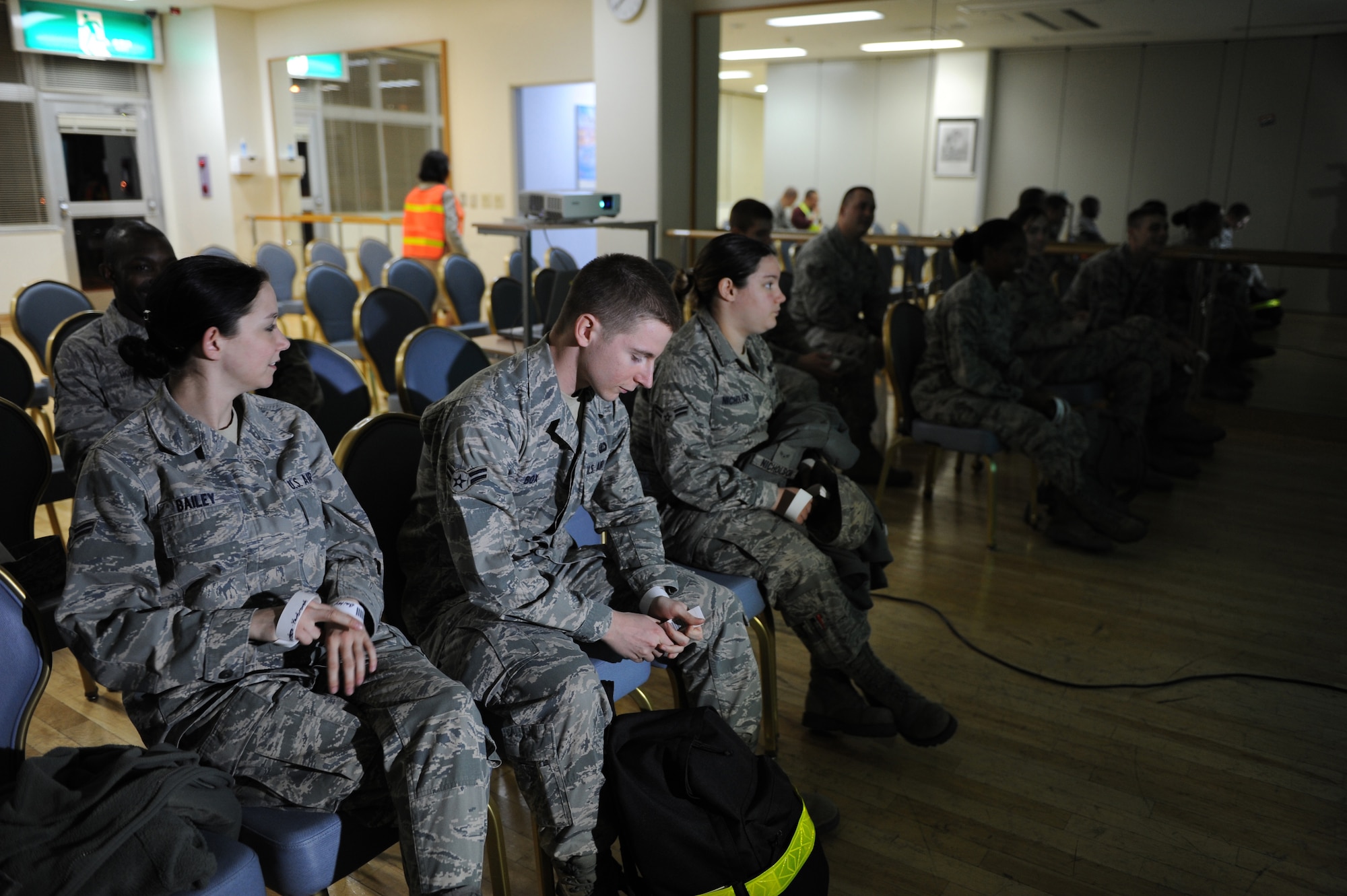 YOKOTA AIR BASE, Japan -- Simulated evacuees listen to  a briefing before going through a processing line during an operational readiness exercise at Yokota Air Base, Feb. 21, 2012. Noncombatants are sometimes  evacuated and relocated during times of war, political and civil instability and natural disaster.   (U.S. Air Force photo/Airman 1st Class Krystal M. Garrett)