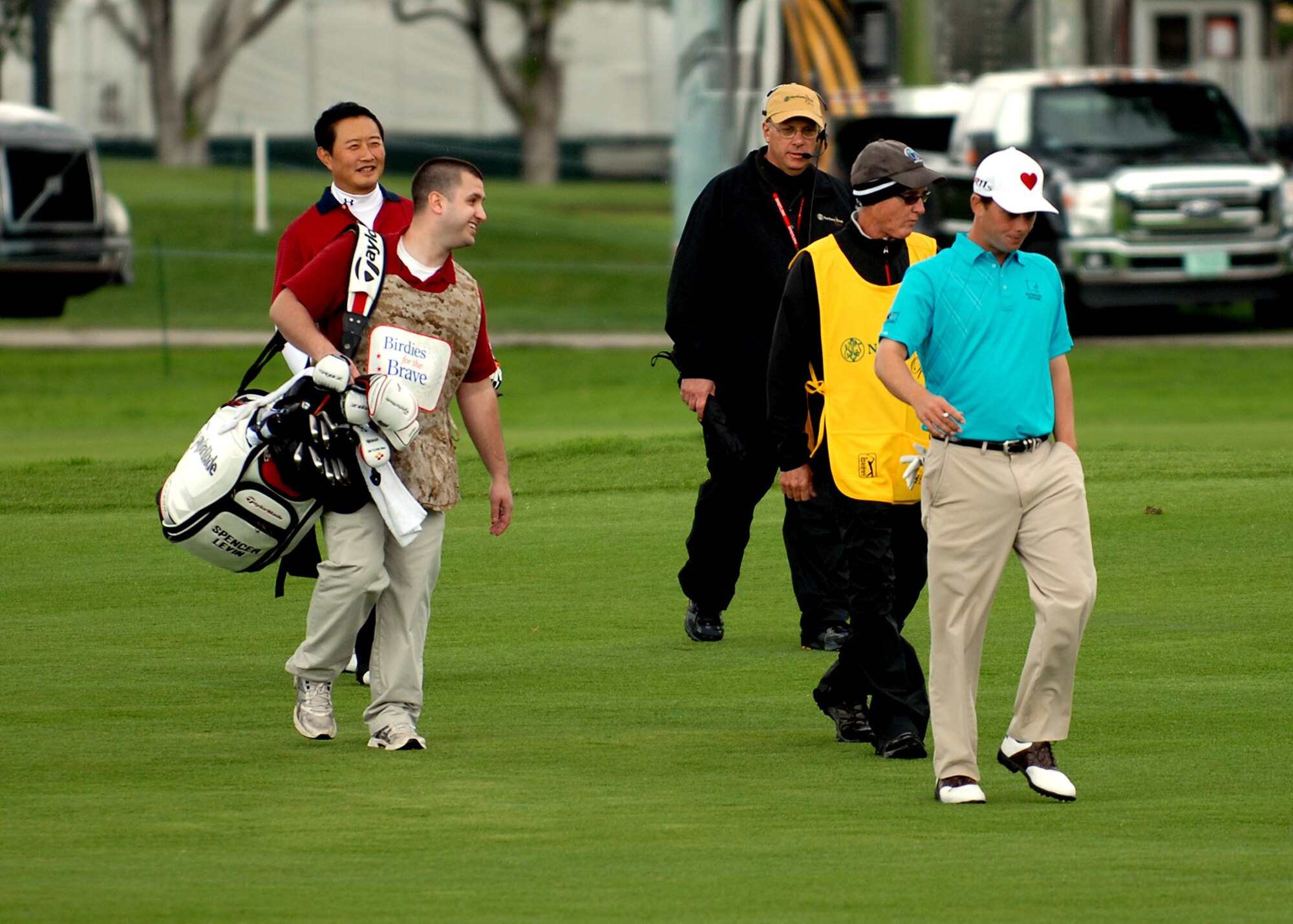 Senior Airman Shane Stapleton (left), 95th Comptroller Squadron, walks across the fairway of the 10th hole at the Riviera Country Club with professional golfer Spencer Levin (right) during the Northern Trust Open Pro-Am Feb. 15. Servicemembers from all branches of the U.S. Military were invited by the NTO to caddie for the pros. (U.S. Air Force photo by Kate Blais)