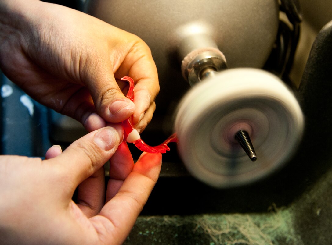 Staff Sgt. Jina Rosales, 28th Medical Operations Squadron dental laboratory technician, polishes an interim removable partial denture in the dental lab at Ellsworth Air Force Base, S.D., Feb. 14, 2012. The dental lab creates a variety of appliances to keep Airmen healthy and deployable. (U.S. Air Force photo by Airman 1st Class Kate Thornton/Released)