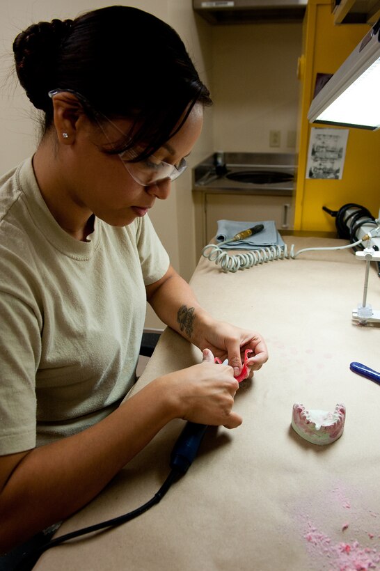 Staff Sgt. Jina Rosales, 28th Medical Operations Squadron dental laboratory technician, uses a smoothing bur to smooth out an interim removable partial denture in the dental lab at Ellsworth Air Force Base, S.D., Feb. 14, 2012. The lab uses molds made of patients’ teeth to complete all of their dentition projects to ensure accuracy of their products. In addition, this process expedites dental appointments, allowing Airmen to get back to the mission. (U.S. Air Force photo by Airman 1st Class Kate Thornton/Released)