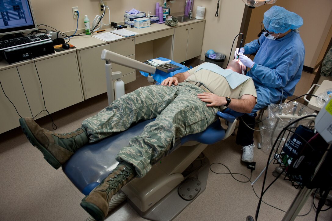 Senior Airman Taylor Johnson, 28th Medical Operations Squadron dental assistant journeyman, starts an annual cleaning on Staff Sgt. Andy Weaver, 28th Communications Squadron client service technician, in the dental clinic at Ellsworth Air Force Base, S.D., Feb. 7, 2012. Airmen receive a professional teeth cleaning once a year as part of staying healthy and ultimately mission ready. (U.S. Air Force photo by Airman 1st Class Kate Thornton/Released)