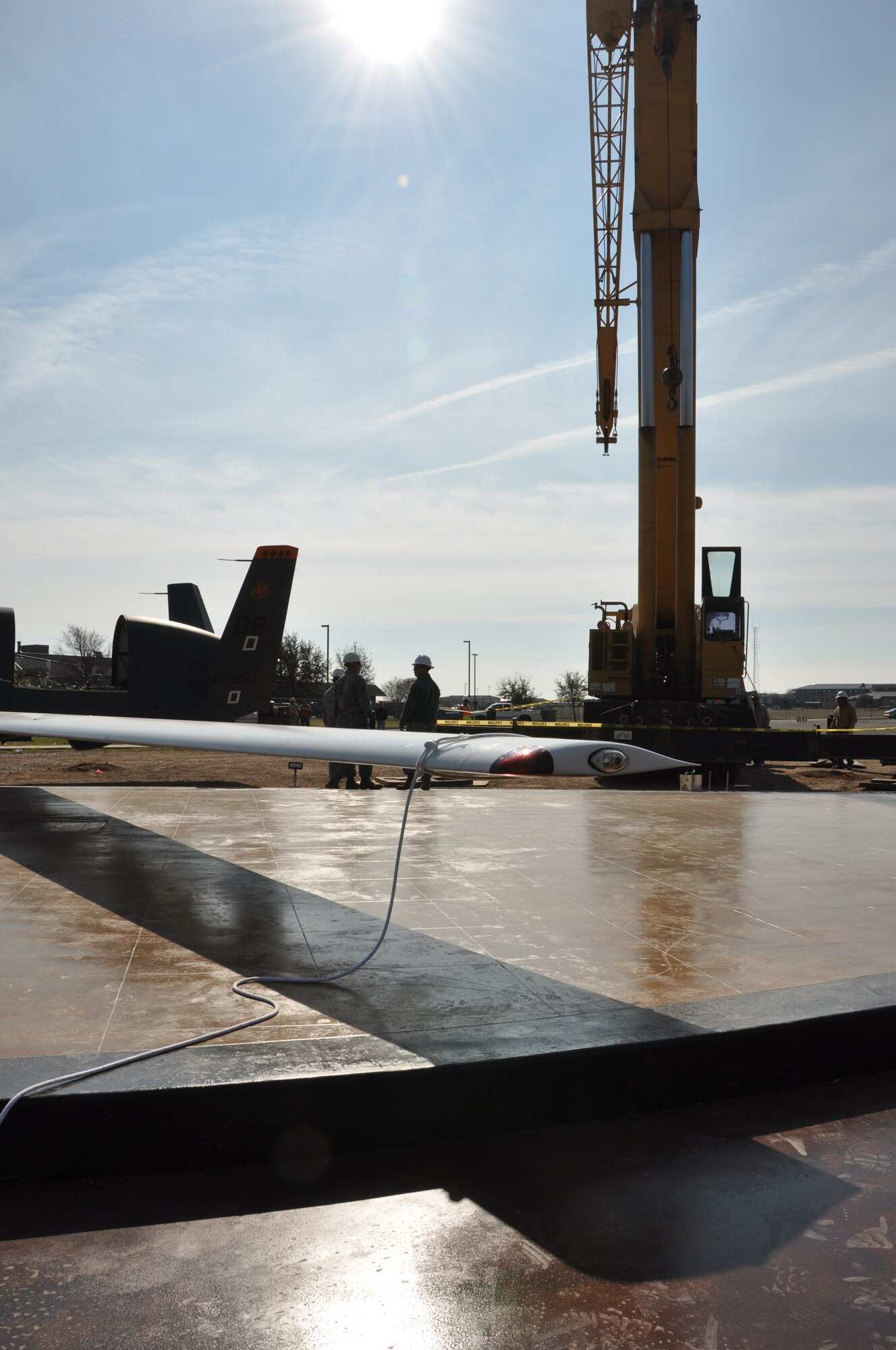 GOODFELLOW AIR FORCE BASE, Texas-- A crane arrives to help an assembly team from Tinker Air Force Base, Okla. move the RQ-4 Global Hawk, the wing’s newest display, to its final display position on a concrete platform near the North Gate. The aircraft, which has been drained of fuel, weighs more than four tons. (U.S. Air Force photo/Airman 1st Class Jessica Keith) 