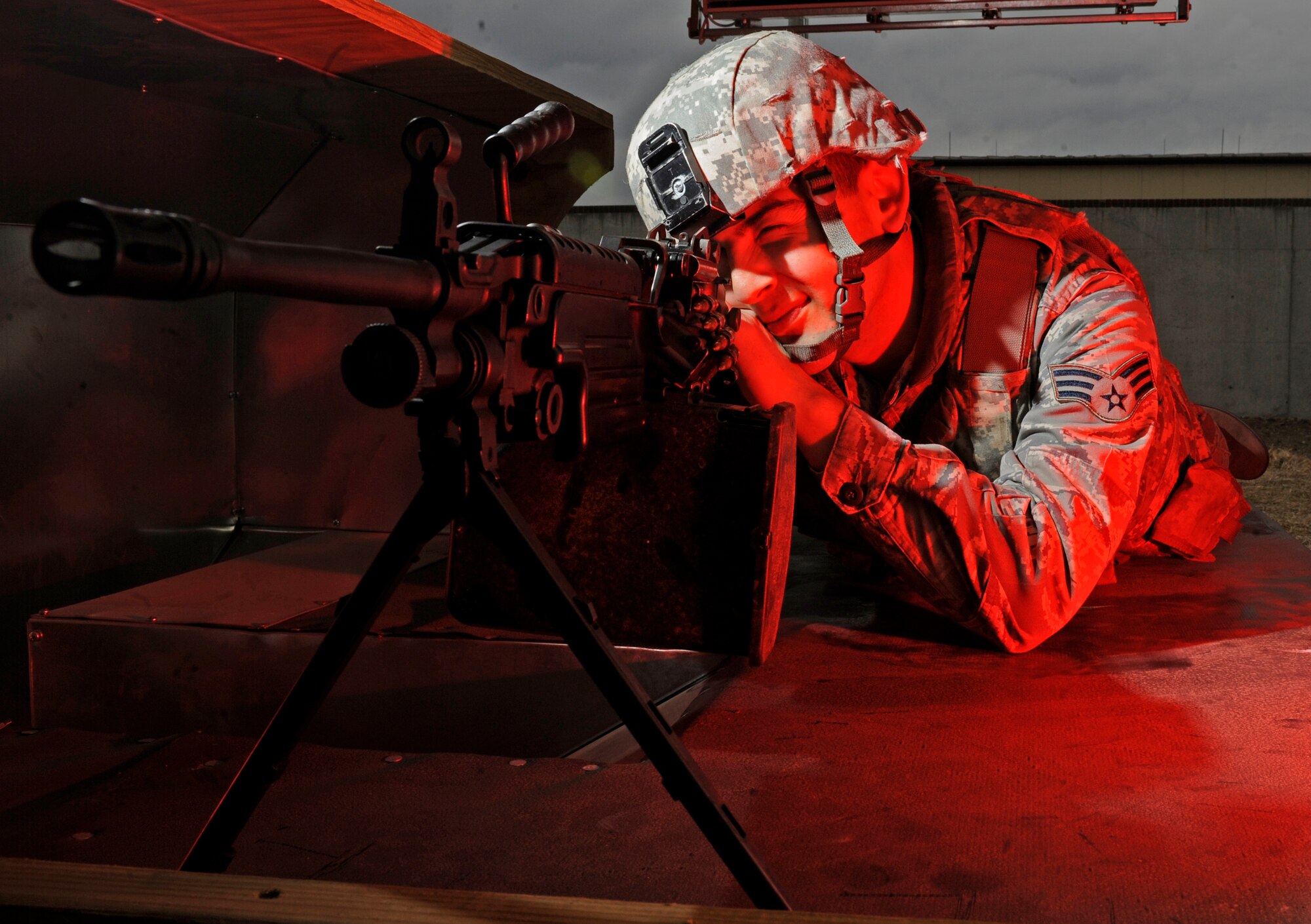 WHITEMAN AIR FORCE BASE, Mo. -- Senior Airman Jesus Barraza, 509th Security Forces Squadron combat arms instructor, demonstrates how to use the M249 machine gun here Jan. 31. The M249 is gas operated and air-cooled with a quick-change barrel, allowing the gunner to rapidly replace an overheated or jammed barrel. A folding bipod is attached near the front of the gun. It can be fed from both linked ammunition and standard magazines, like those used in M16 and M4 rifles. This allows the gunner to use the magazines as an emergency source of ammunition in the event that the gunner runs out of linked rounds.   (U.S. Air Force photo by Staff Sgt. Alexandra M. Boutte) (RELEASED)