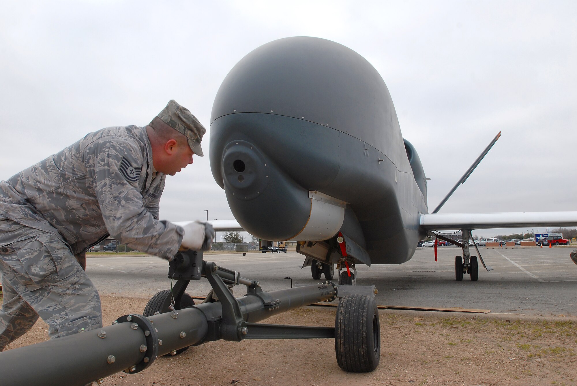 GOODFELLOW AIR FORCE BASE, Texas -- Tech. Sgt. Neal Camren, 76th Aircraft Maintenance Group Tinker Air Force Base,Okla., lowers the wheels of the RQ-4 Global Hawk tow bar here Feb. 8. The Global hawk has a maximum flight altitude of over 60,000 ft. and a maximum endurance of 30 hours. (U.S. Air Force photo/Airman 1st Class Michael Smith)