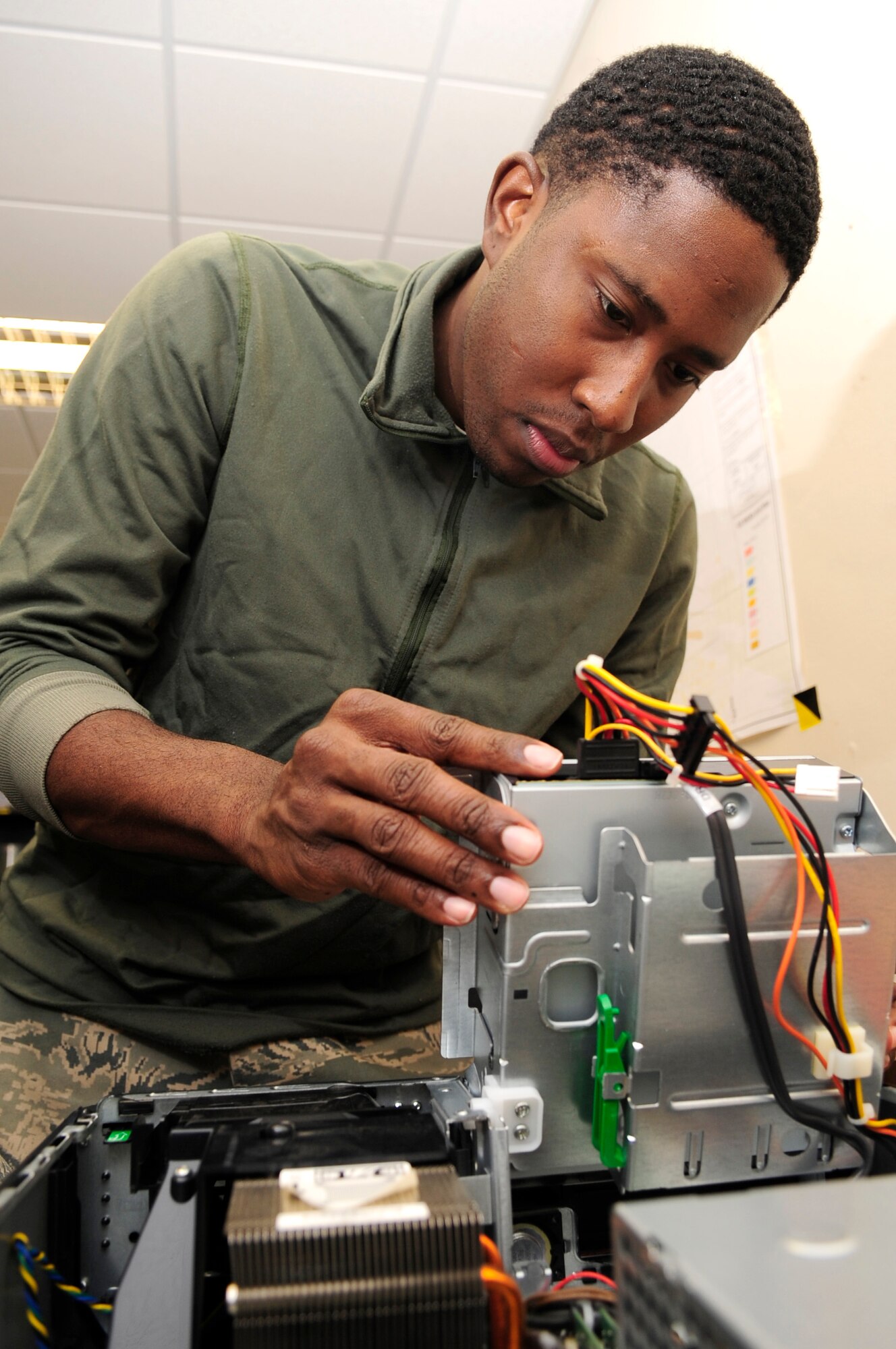 2/21/2012 - RAF MILDENHALL, England – Staff Sgt. Ronald Reeves, 100th Communications Squadron client support team supervisor, replaces the CD/DVD ROM drive of a desktop computer here Feb. 17, 2012. On average the 100th CS changes the hardware for 30 desktop computers monthly. (U.S. Air Force photo/Senior Airman Ethan Morgan)