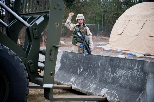U.S. Air Force Staff Sgt. Todd Messer, 23d Civil Engineer Squadron water and fuels systems journeyman, guides a forklift to its position during an operational readiness exercise Feb. 15, 2012, at Moody Air Force Base, Ga. Messer and his unit provided daily maintenance at the field training exercise site and performed post-attack reconnaissance sweeps as needed. They also supplemented the 23d Security Forces Squadron and helped conduct security duties. (U.S. Air Force photo by Staff Sgt. Jamal D. Sutter/Released) 
