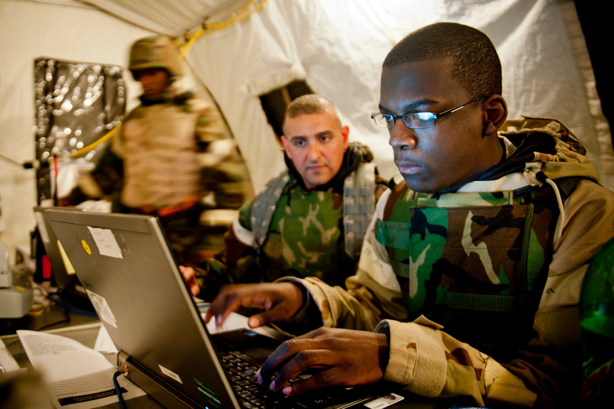 U.S. Air Force Senior Airman DeVondre McNeill, right, and Master Sgt. Jason Chrisman, both of the 23d Force Support Squadron, review personnel data during an operational readiness exercise Feb. 15, 2012, at Moody Air Force Base, Ga. During the exercise, the two Airmen were part of the personnel support for contingency operations team and were responsible for all personnel related issues to include accountability, casualties, emergency leave, promotions, reenlistments and more. (U.S. Air Force photo by Staff. Sgt. Jamal D. Sutter/Released) 