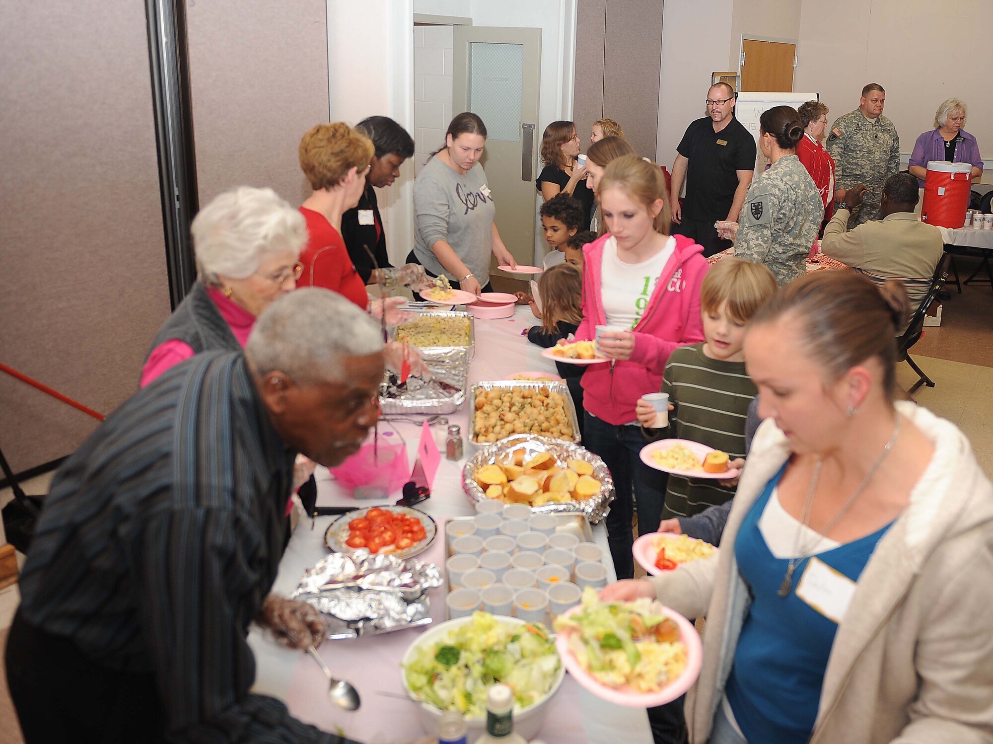 Fort Eustis Military and Family Life Consultant Program volunteers serve military spouses and families assorted desserts during the Dinner for Families of Deployed event at the Fort Eustis Regimental Chapel Feb 14. The Fort Eustis Regimental Chapel community lends their support every second Tuesday of the month by sponsoring a free dinner for families and spouses of deployed servicemembers. (U.S. Air Force photo by Staff Sgt. Antoinette Gibson/Released)