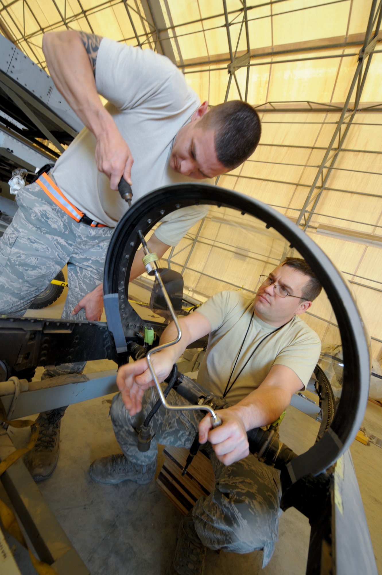 Senior Airman Matthew Goff and Staff Sgt. John Self, 332nd Expeditionary Maintenance Squadron egress members, secure a transparency to an F-16 Fighting Falcon canopy frame at an undisclosed location in Southwest Asia, Feb. 19, 2012. Goff and Self use a 30 psi limiter on when tightening certain areas of the canopy. The limiter allows 30 pounds of pressure to be applied to the bolt. Goff is a native of Williamson, N.C., and Self is a native of Atlanta, Texas. Both are deployed from Shaw Air Force Base, S.C. (U.S. Air Force photo by Staff Sgt. Joshua J. Garcia/Released)