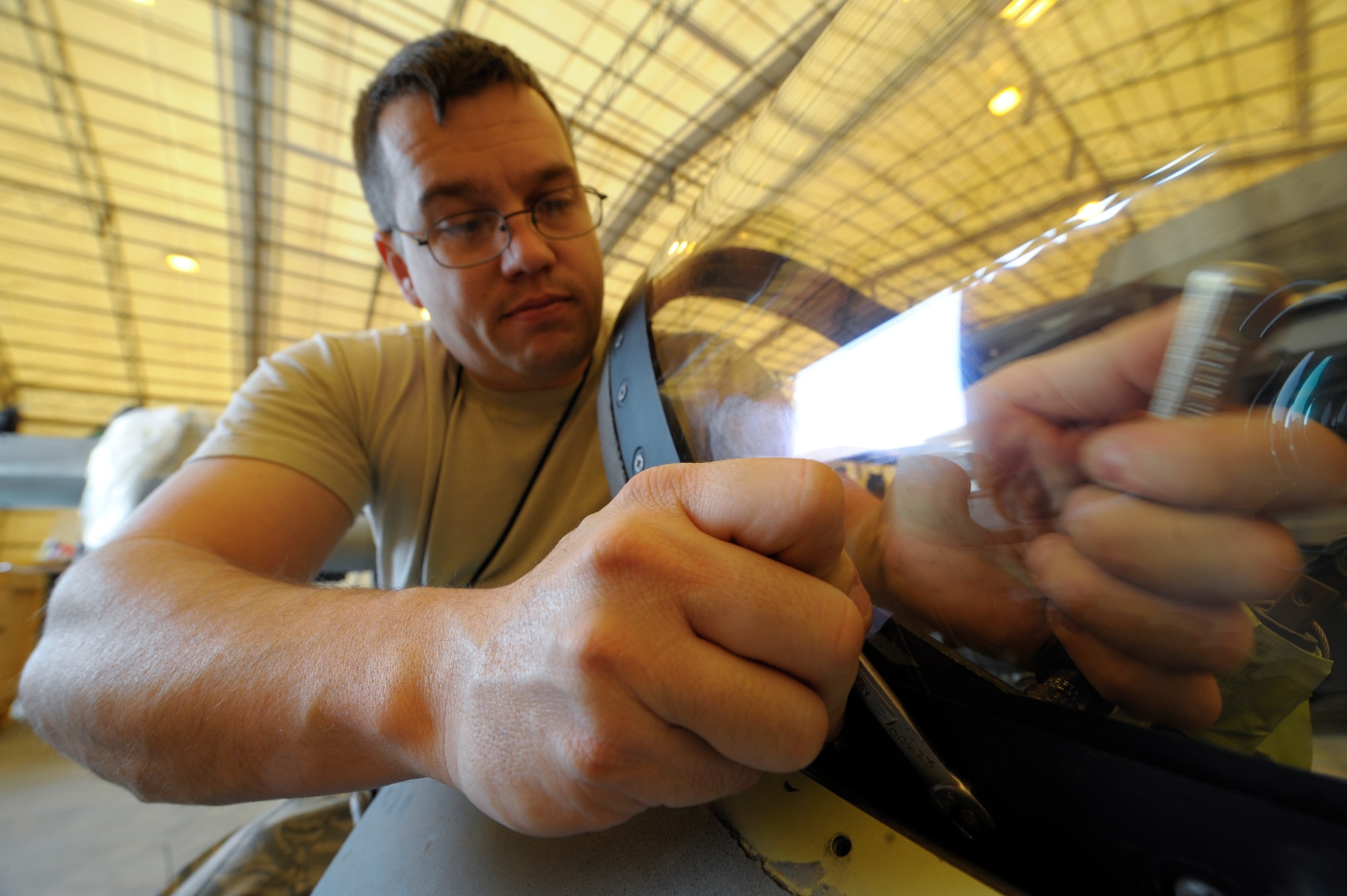Staff Sgt. John Self, 332nd Expeditionary Maintenance Squadron egress member, tightens a transparency into an F-16 Fighting Falcon canopy frame at an undisclosed location in Southwest Asia, Feb. 19, 2012. The transparency is secured to the frame along with a dry seal to ensure the canopy will not lose cabin pressure during flight. Self is deployed from Shaw Air Force Base, S.C. and is a native of Atlanta, Texas. (U.S. Air Force photo by Staff Sgt. Joshua J. Garcia/Released)