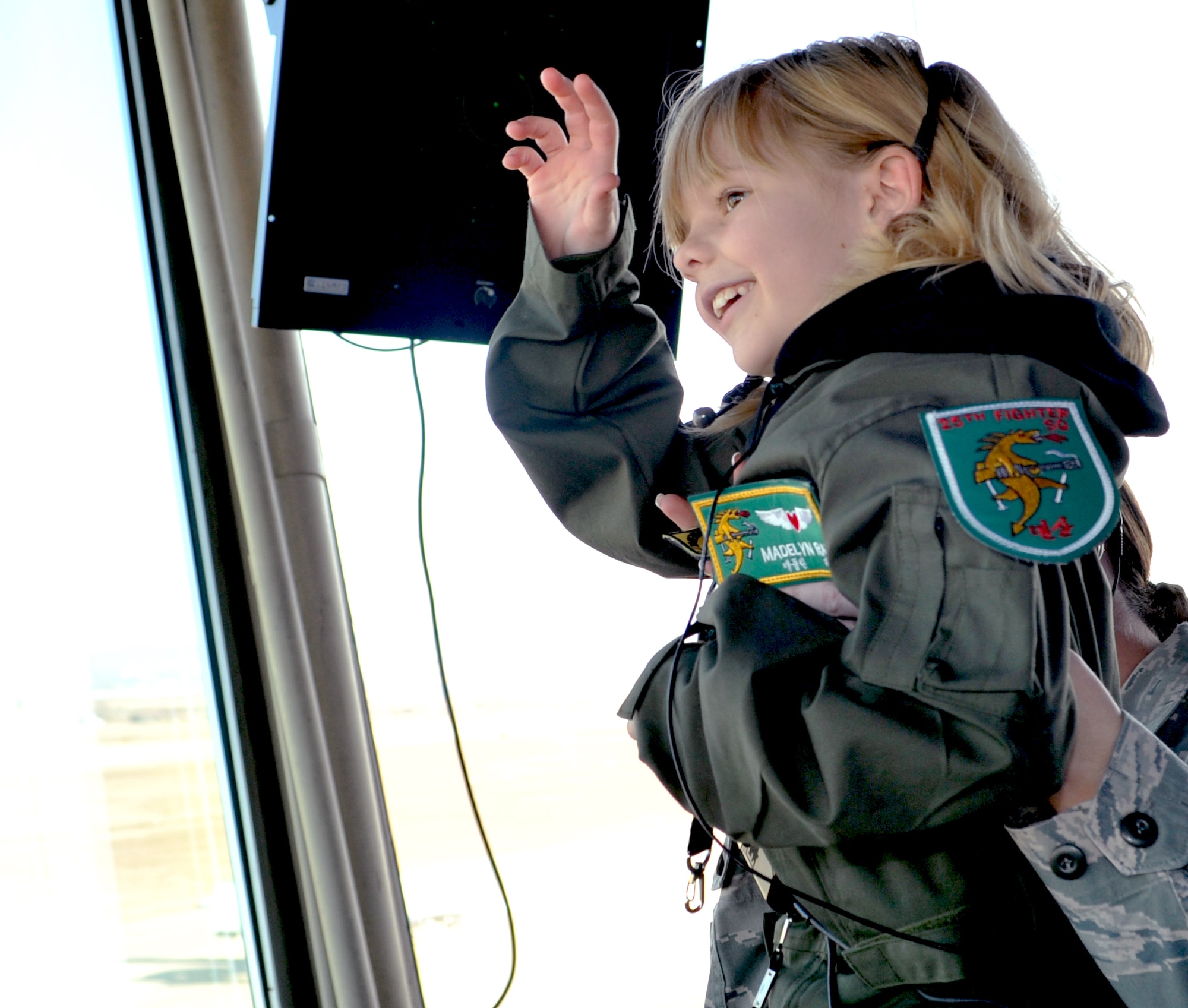 Madelyn Ray waves hello to an A-10 Thunderbolt II pilot while visiting Osan Air Base’s traffic control tower Feb. 17, 2012. Madelyn is an honorary Pilot-for-a-Day, which consisted of touring the flightline and learning about the combat capabilities of the F-16 Fighting Falcon and A-10. Madelyn toured two fighter squadrons and the air traffic control tower, and flew in a simulator as part of her day. (U.S. Air Force photo/Staff Sgt. Stefanie Torres)