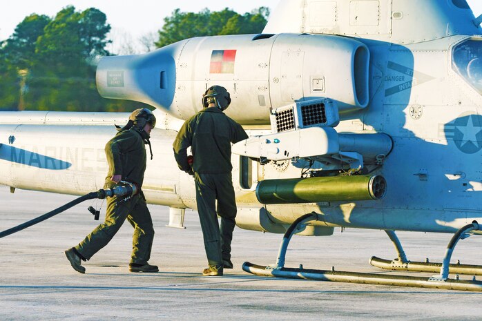 Cpl. Theodore M. Young and Lance Cpl. Stephen A. Meyer bring the fuel line from the tactical bulk fuel delivery system in the CH-53E to refuel the AH-1W Cobra. Marines with Marine Heavy Helicopter Squadron 461 conducted training setting up a Forward Arming and Refueling Point at Blackstone Army Airfield, Dec. 13.