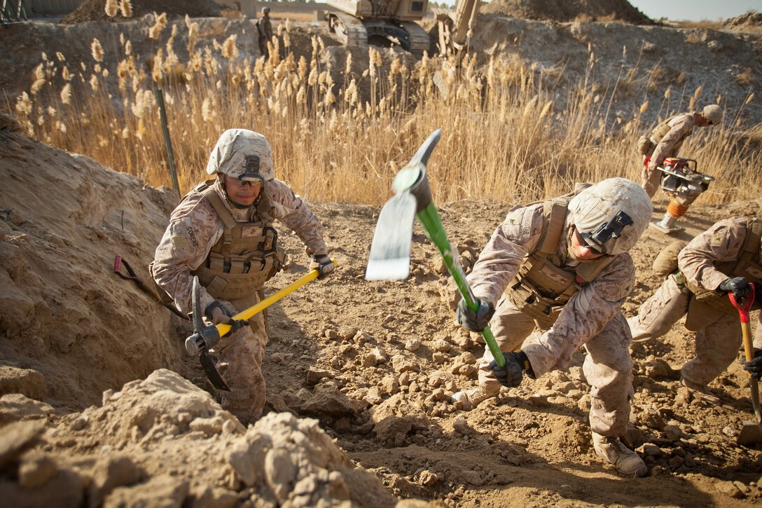 Lance Cpl’s Fredis Coreas (left) and Nathan Morningstar, both combat engineers with Bridge Platoon, Alpha Company, 9th Engineer Support Battalion, use pickaxes to remove some hardened earth in order prepare an area for the construction of a bridge near Combat Outpost Rankel in the district of Garmsir, Helmand province, Jan. 29. The Marines of Bridge Platoon endured a 5-day convoy in order to replace a temporary bridge with a more permanent structure that would increase mobility for Marines operating in the area.