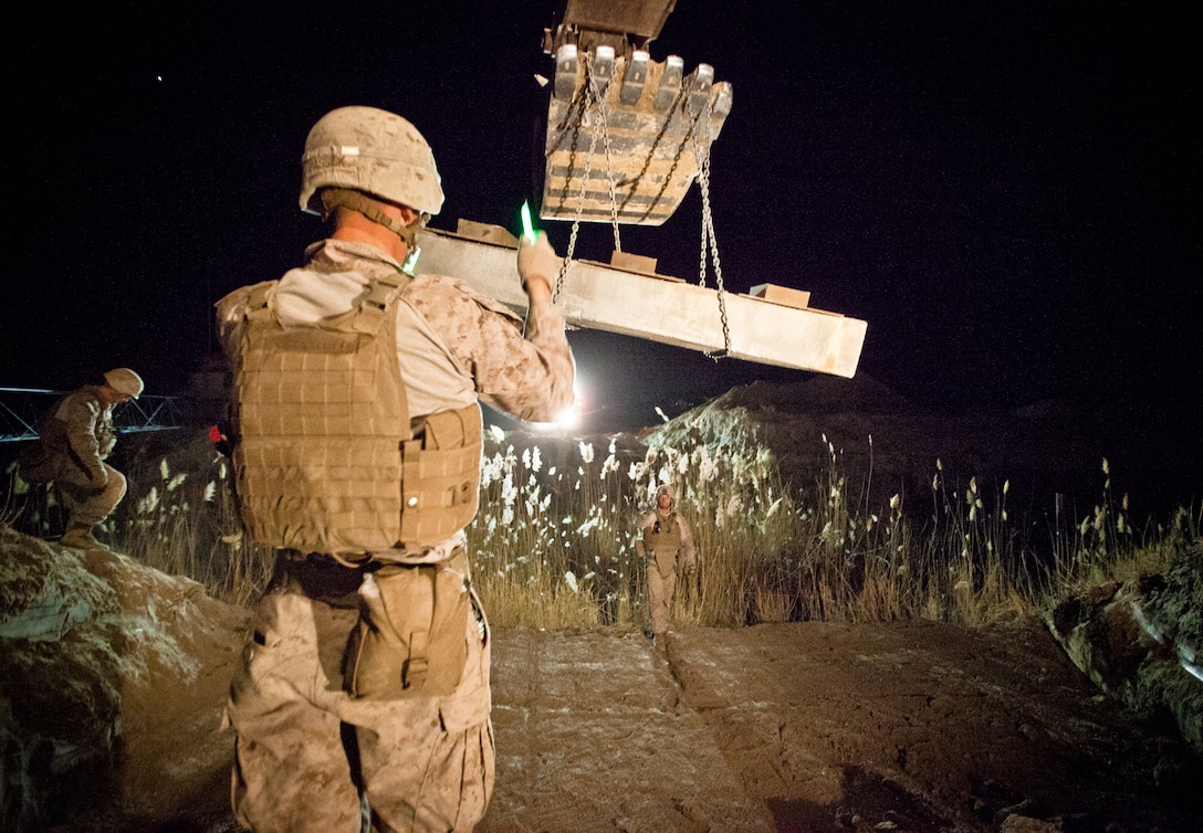 Marines with Bridge Platoon, Alpha Company, 9th Engineer Support Battalion, use a welding torch to separate two 40-foot steel I-beams used in the construction of a bridge near Combat Outpost Rankel in the district of Garmsir, Helmand province, Jan. 29. The Marines of Bridge Platoon endured a 5-day convoy in order to replace a temporary bridge with a more permanent structure that would increase mobility for Marines operating in the area.