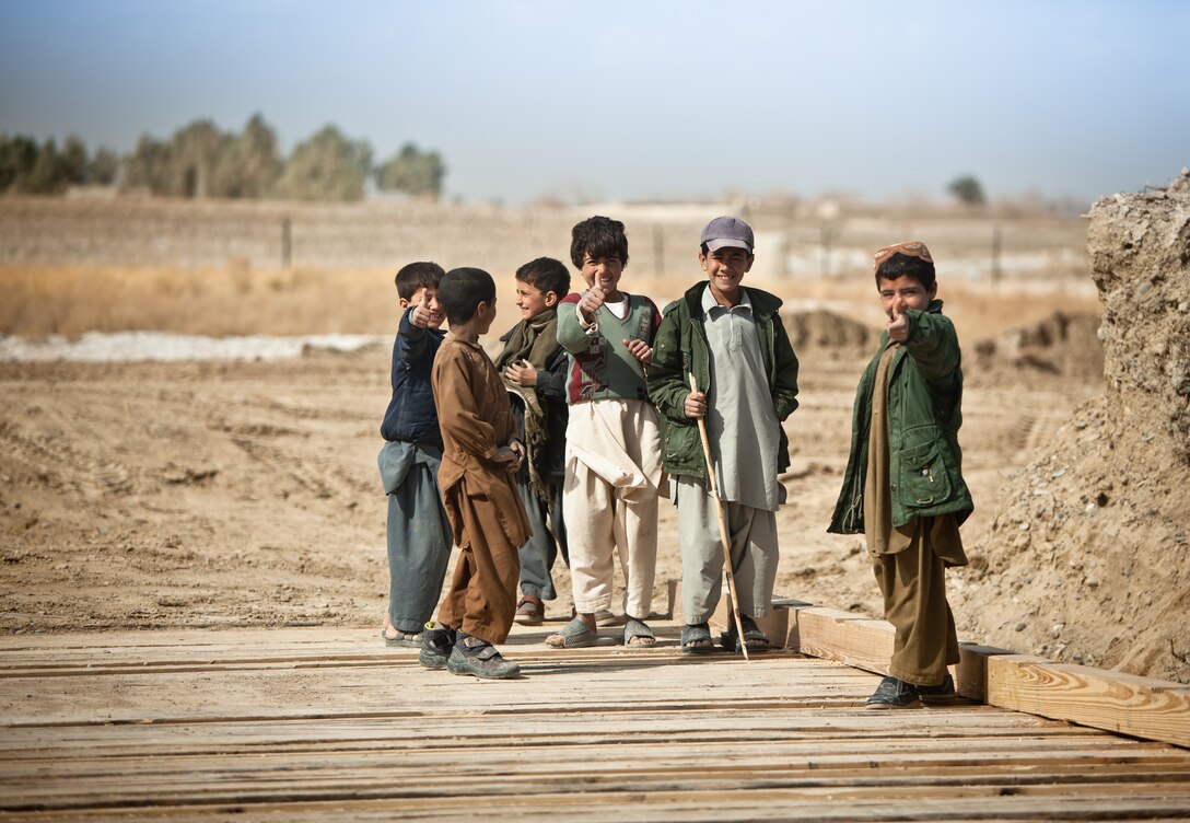 Afghan children give their approval of the new bridge constructed near Combat Outpost Rankel in the district of Garmsir, Helmand province, Jan. 29. The Marines of Bridge Platoon, Alpha Company, 9th Engineer Support Battalion endured a 5-day convoy in order to replace a temporary bridge with a more permanent structure that would increase mobility for Marines operating in the area.