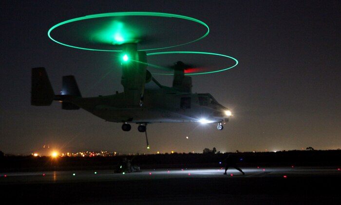 Marines from Landing Support Company, Combat Logistics Regiment 17, 1st Marine Logistics Group, rig a 1,000-pound cement block to the bottom of an MV-22 Osprey during a training exercise at Marine Corps Air Station Miramar, Calif., Nov. 8. The training allowed both the landing support specialists on the ground and pilots in the air to train for night helicopter support operations.