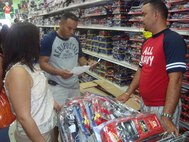 SANTIAGO, Dominican Republic - Nilda Quezada, left, 1st Lt. Jose Quezada, middle, and Jose Grullon, right, review a toy list at El Mundo De Juguetes after filling the first of many carts with toys in Santiago, Dominican Republic, Dec. 21, 2008. Each list is broken down by grade and gender.