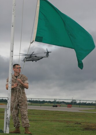 Sgt. Jason P. Lukasek, a weather forecaster aboard Marine Corps Air Station New River, N.C., raises a heat index flag while a CH-53E Super Stallion takes off in the backround, Sept. 27. 