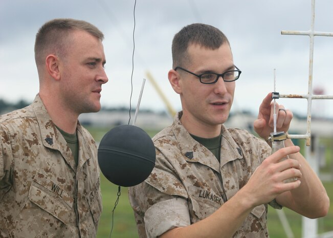 Sgt. Nathan R. Will and Sgt. Jason P. Lukasek, weather forecasters aboard Marine Corps Air Station New River, N.C., take measurements to determine the heat index. 