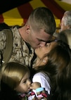 Cpl. Griffin E. Sandifer, Marine Wing Support Squadron 272 Aircraft Rescue and Firefighter, embraces his wife and child, after returning home from a seven-month deployment to Afghanistan, Oct. 7. Approximately 250 Untouchables of MWSS-272 came home to Marine Corps Air Station New River in a homecoming event, Oct. 7.