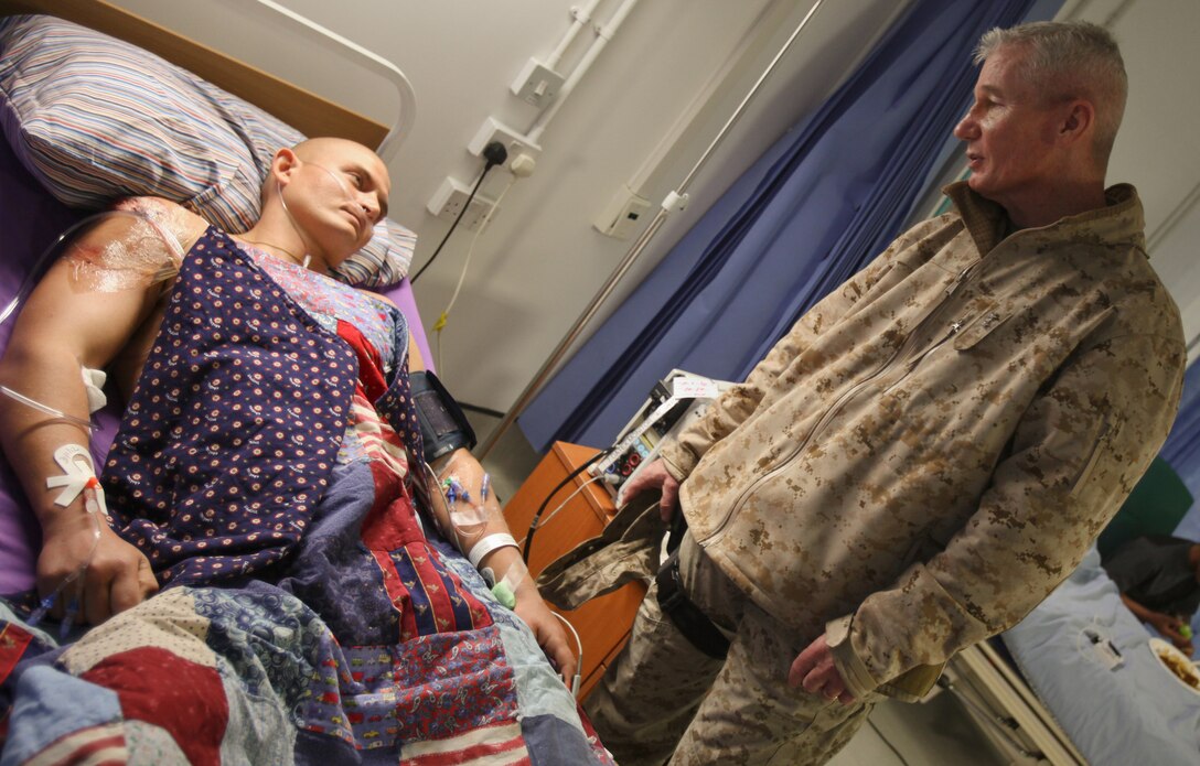 Maj. Gen. John A. Toolan, commanding general of Regional Command Southwest, visits with Sgt. Jacob P., a Danish tank commander with Jutland Dragoon Regiment, at the Role 3 Hospital aboard Camp Bastion, Feb. 1.  Jacob, a native of Holstebro, Denmark, sustained a gunshot wound to his right shoulder while providing overwatch during Operation Shamali Kamarband on Jan. 5.  Then on Jan. 31 he was wounded by three gunshot wounds, one to his right shoulder and two in his left leg.  On both occasions, Jacob remained calm under fire and instructed his crew to fire on the insurgents' position, killing them.