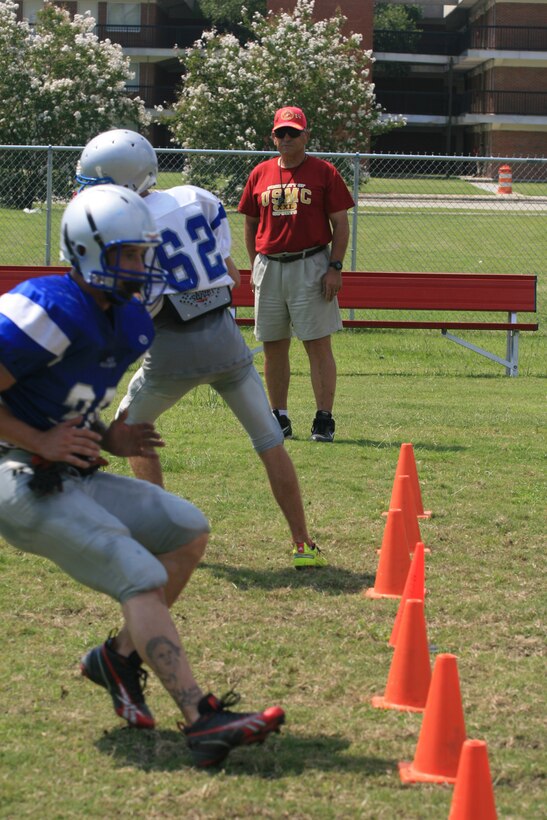 Coach Bill Stinkowski watches the New River Knights conduct speed drills on the practice field aboard Marine Corps Air Station New River Aug. 23. The Knights are training for the seasons first game next month.