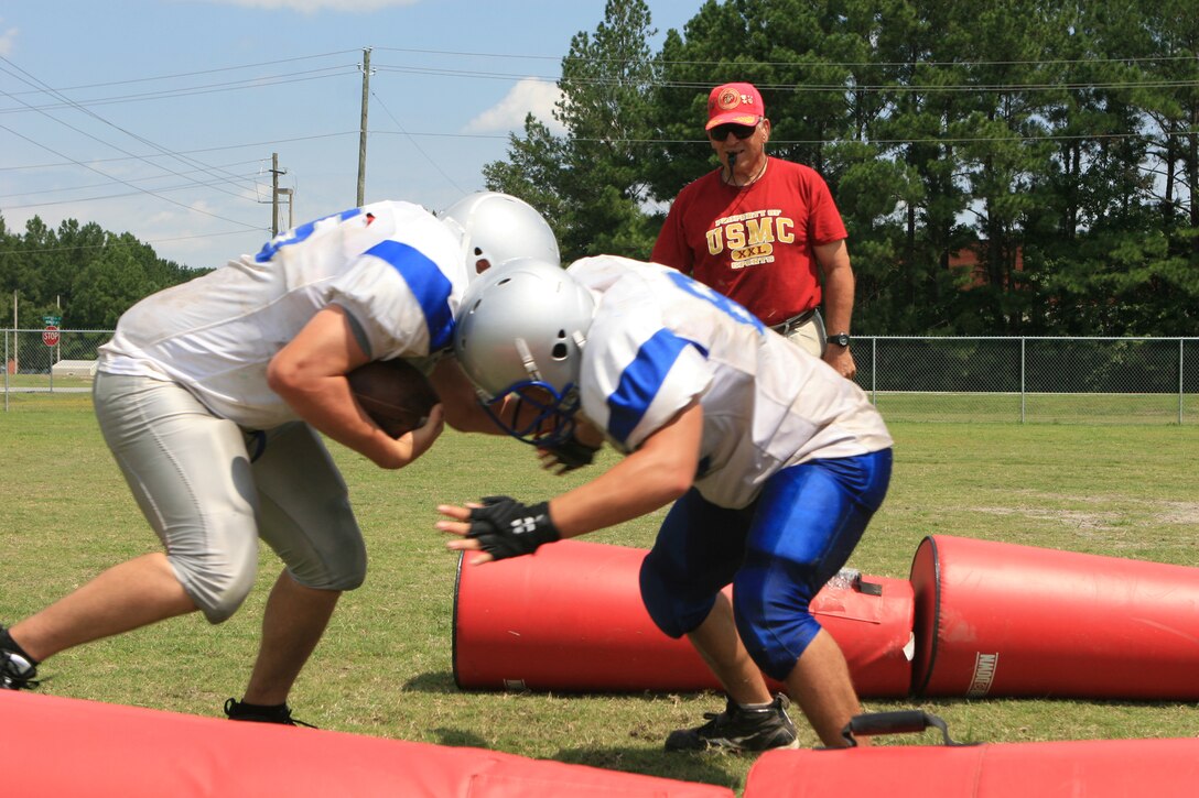 The New River Knights practice hitting drills to improve their tackling skills on the practice field aboard Marine Corps Air Station New River, Aug. 23. 
