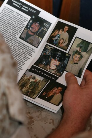 A Marine from Marine Medium Tiltrotor Squadron 264, reads the biography of Staff Sgt. Thomas J. Dudley, before a memorial Aug. 26 for the beloved Marine who sacrificed his life in support of Operation Enduring Freedom.
