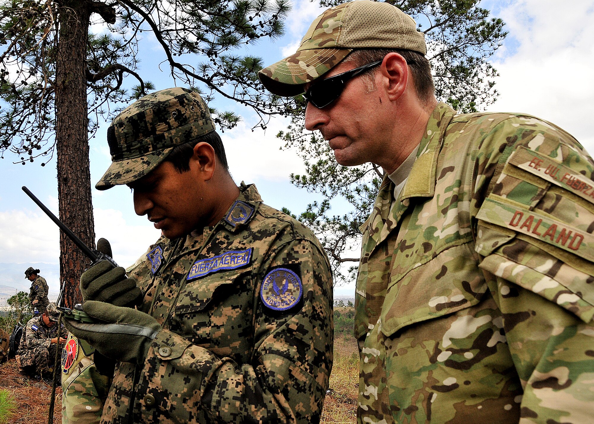 Tech. Sgt. Troy Daland, 571st Mobility Support Advisory Squadron Survival, Evasion, Resistance and Escape specialist air advisor, looks on as a Honduran Air Force aircrew member practices communicating their position to the pilot during the vectoring application of the aircrew survival seminar at Tamara, Honduras, Feb. 15.  (U.S. Air Force photo by Tech. Sgt. Lesley Waters)